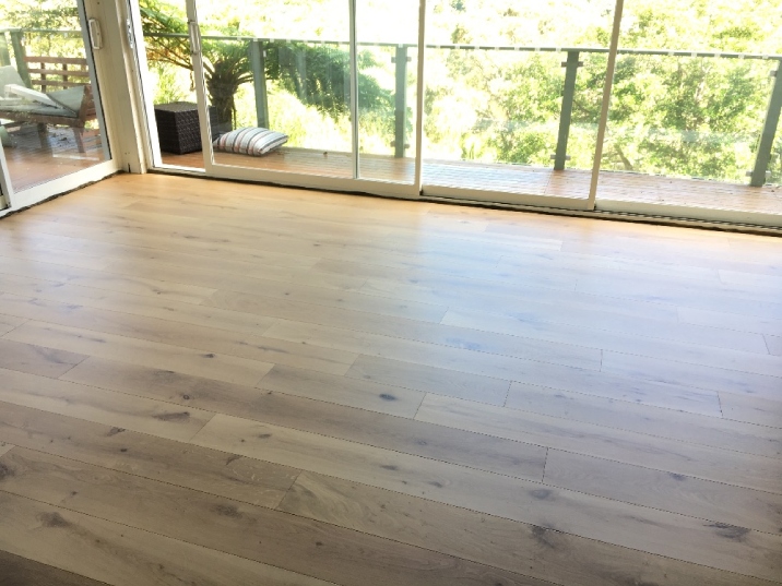Light brown timber flooring near the balcony of a home.