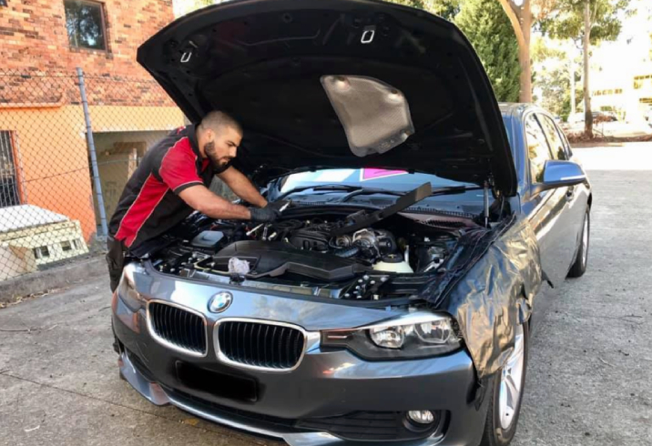 Mechanic working on the engine of a luxury car.